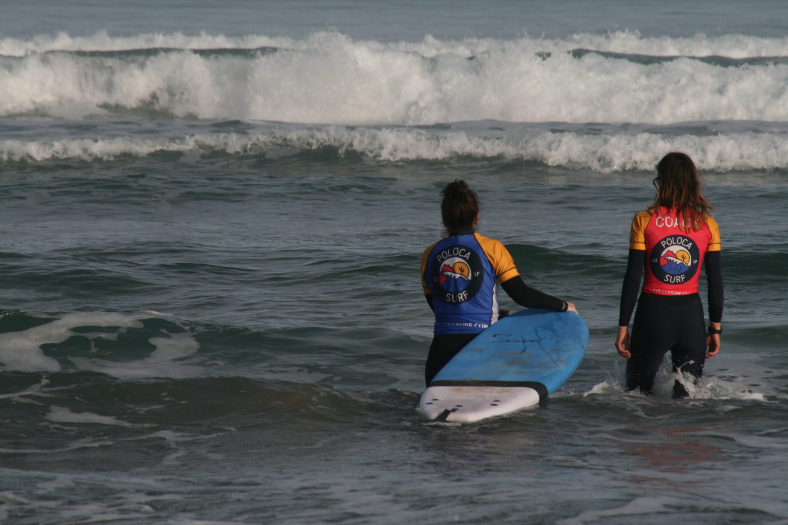 coach going surfing with surf student ocean Famara Lanzarote