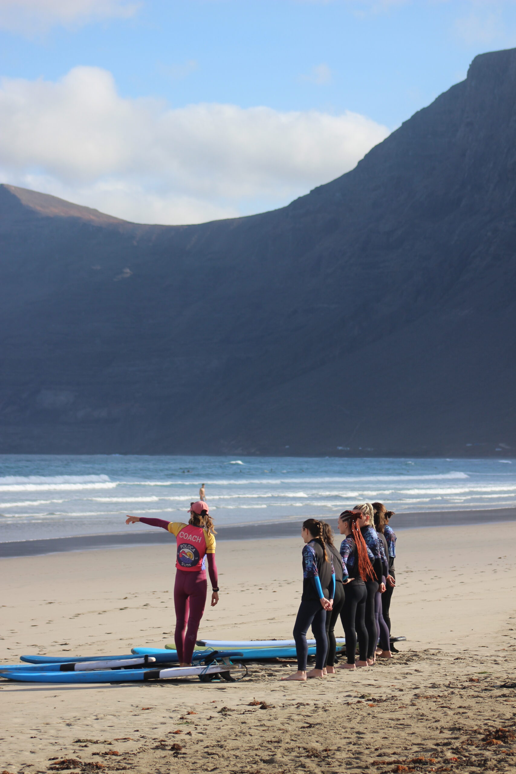zajecia-male-grupy-lanzarote-famara trenerka surfingu i uczniowie na plaży Famara, lekcja surfingu na Lanzarote